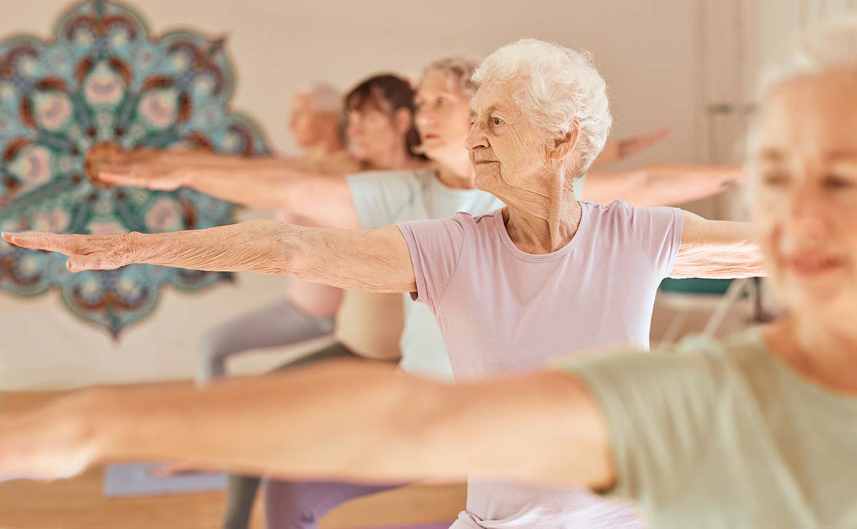 Elderly women practicing yoga, demonstrating the importance of holistic osteoporosis treatment