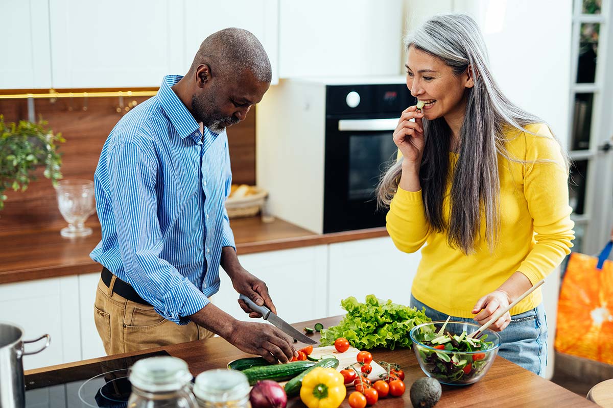 Middle-aged couple preparing a healthy meal, emphasizing nutrition’s role in building stronger bones