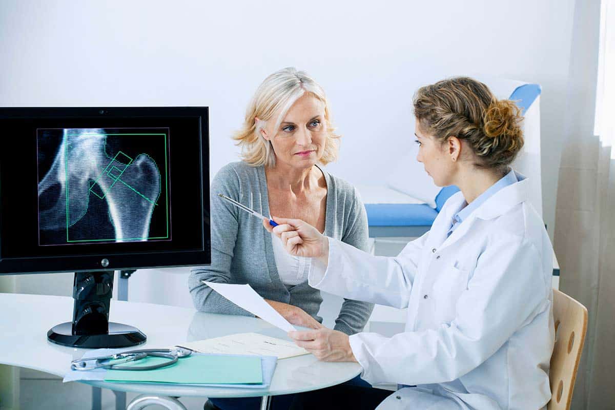 Doctor explaining bone density test results to a senior woman, raising awareness and understanding of bone density tests